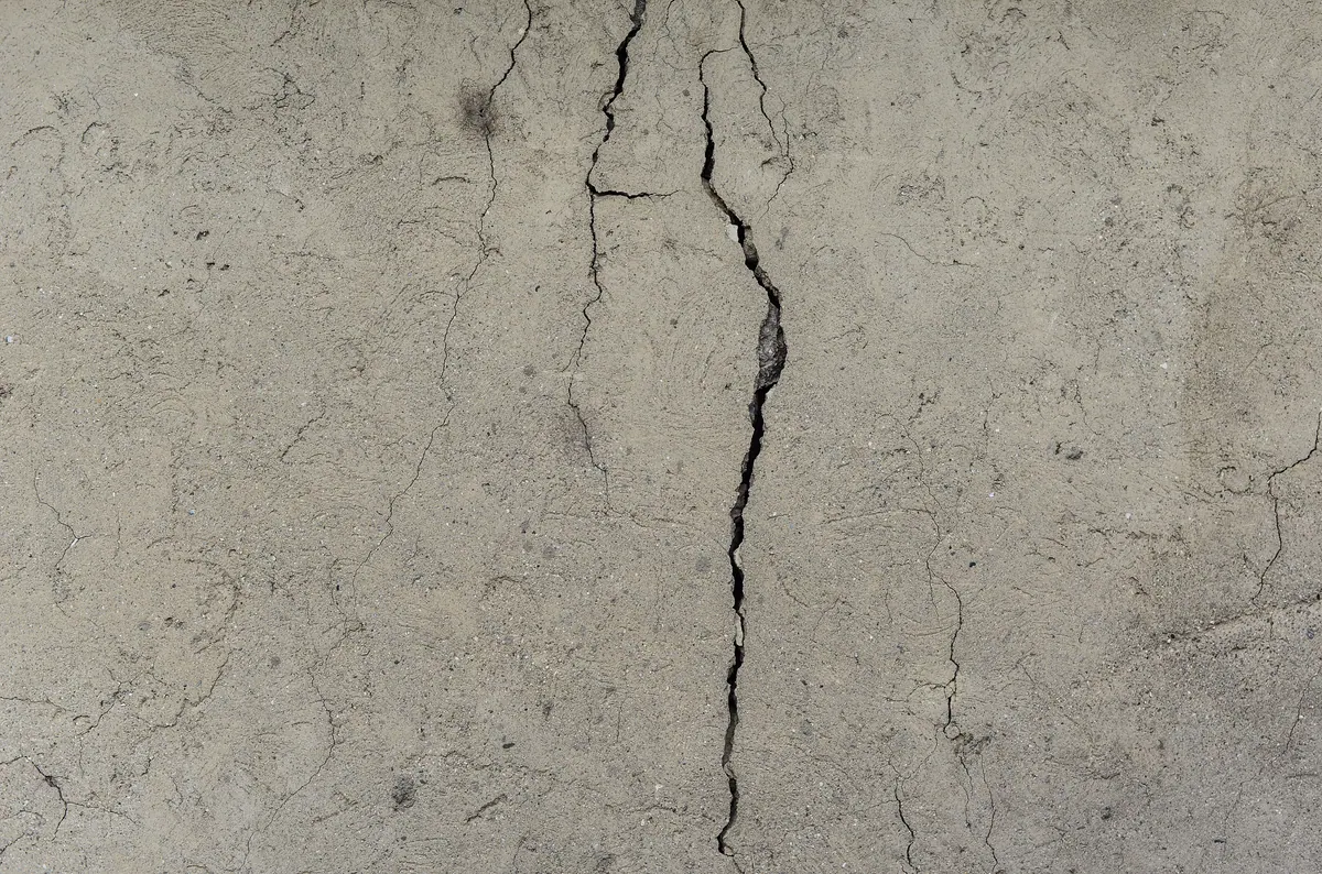 A single crack running down the face of a concrete wall.