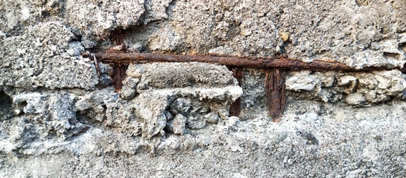 Spalled concrete with corroded reinforcement exposed at the surface.