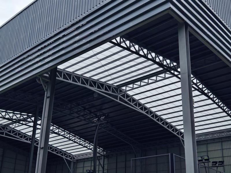 Steel portal frames and roof trusses seen from below.