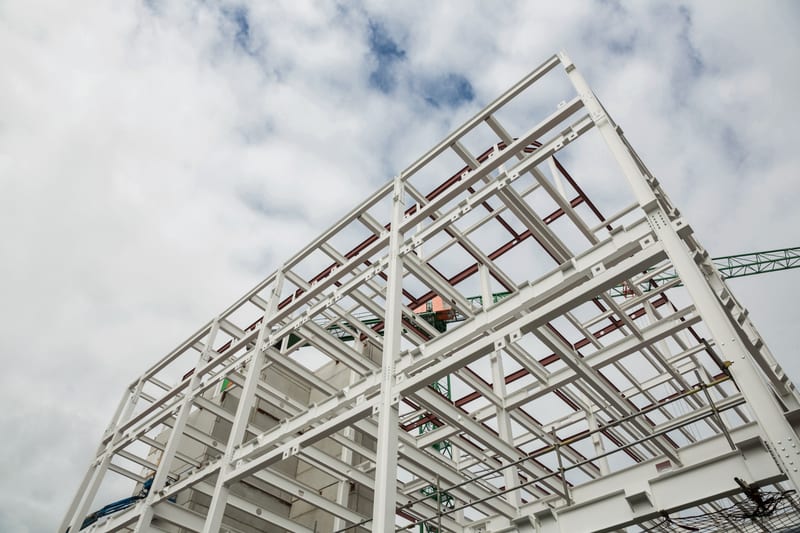 A multi-storey steel frame under construction, seen from below.