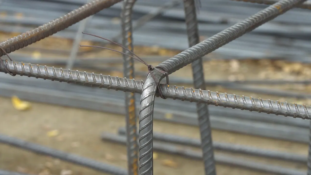 Two reinforcing bars crossing, tied together with wire.