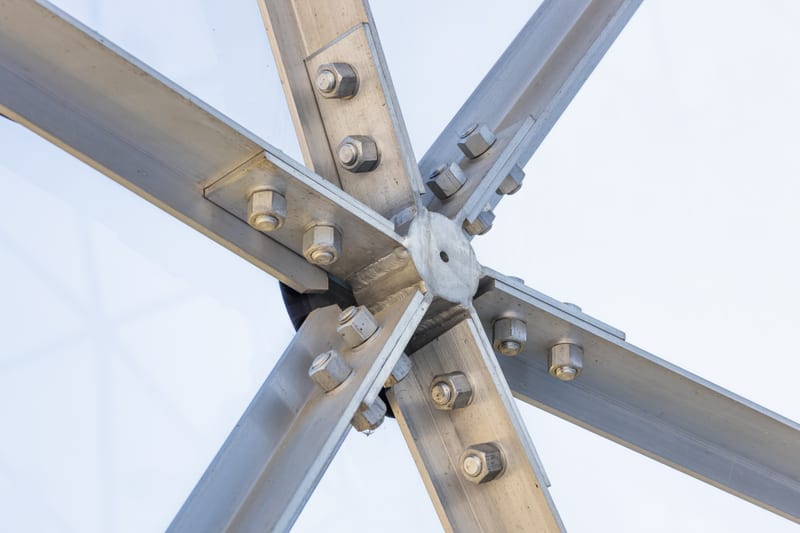 A bolted steel truss node where several members meet.